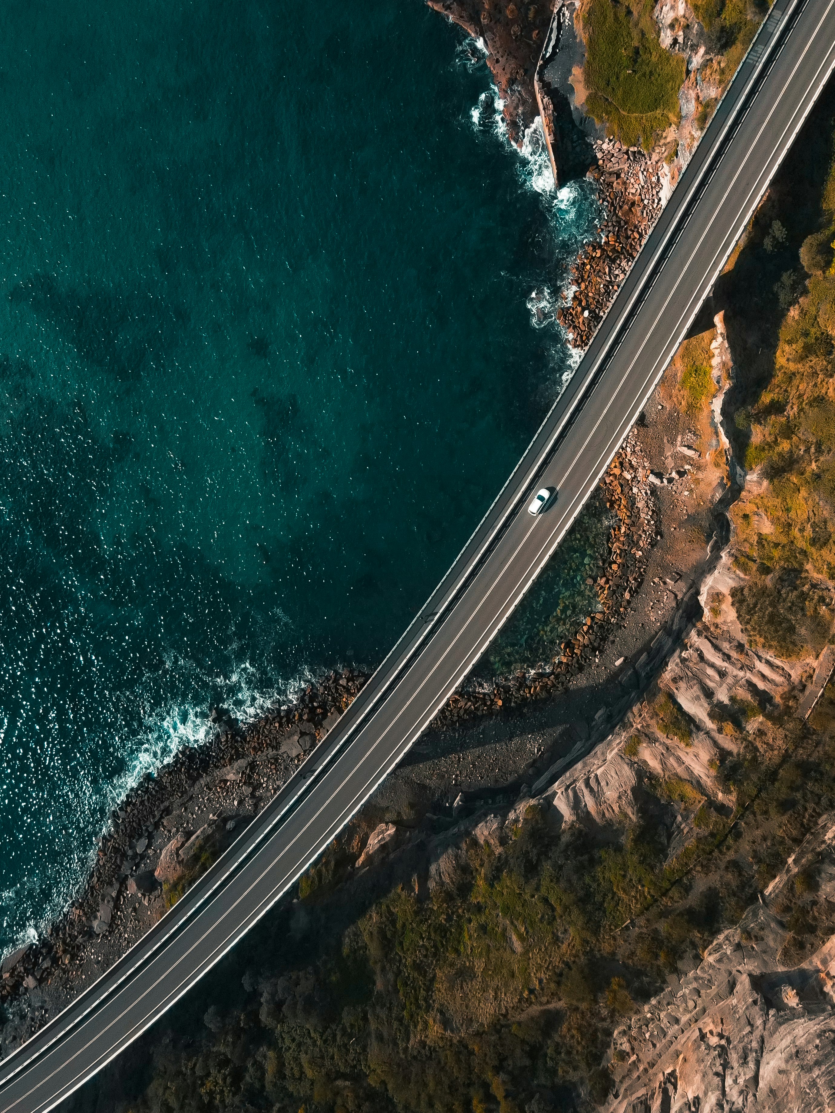 aerial view of road beside body of water during daytime